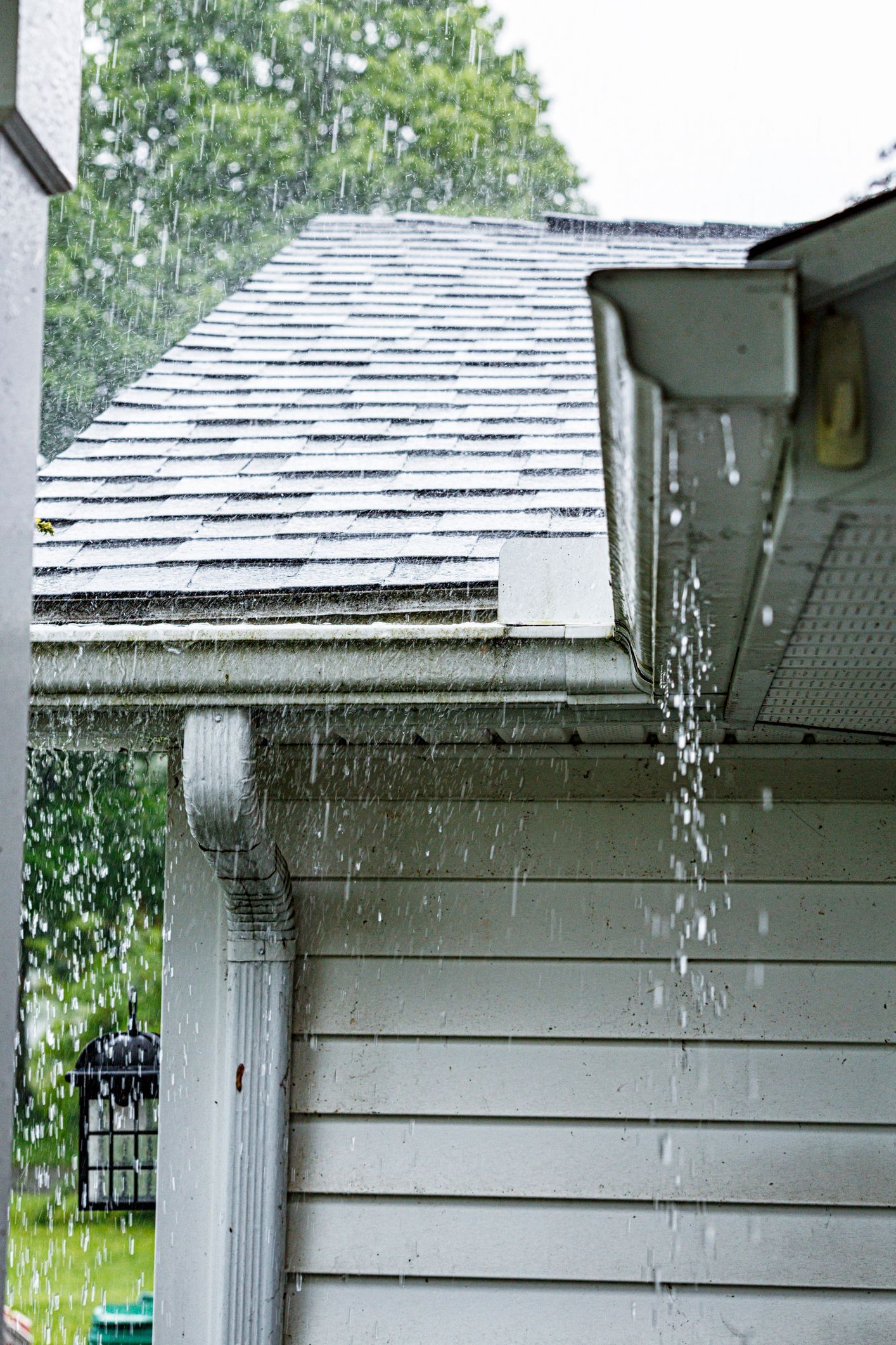 Rain is falling from the gutters of a house