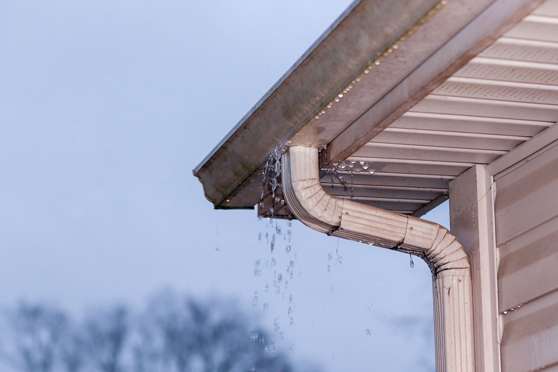 Rain is falling from the gutter of a house