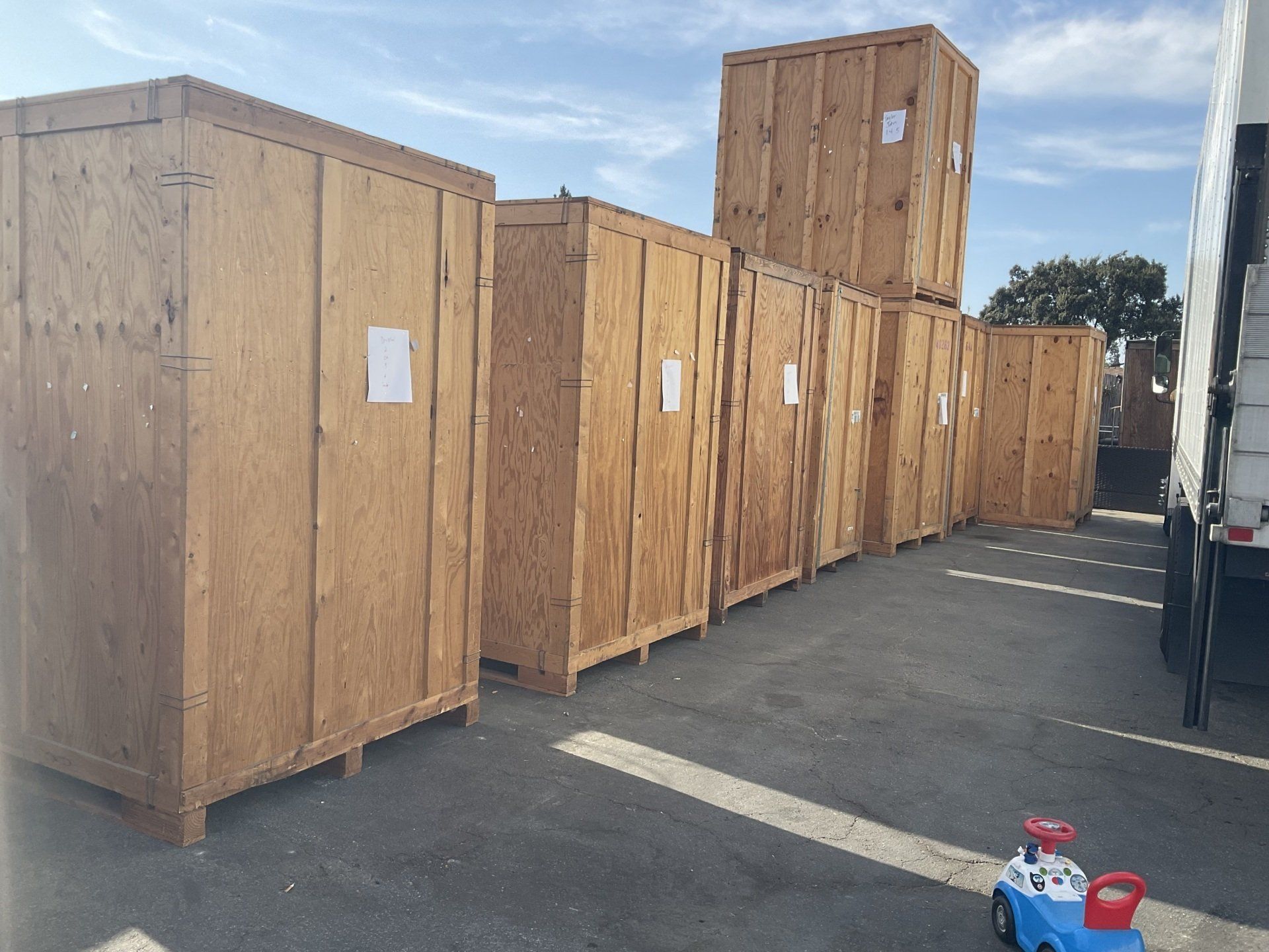 A toy car is sitting in front of a row of wooden crates.