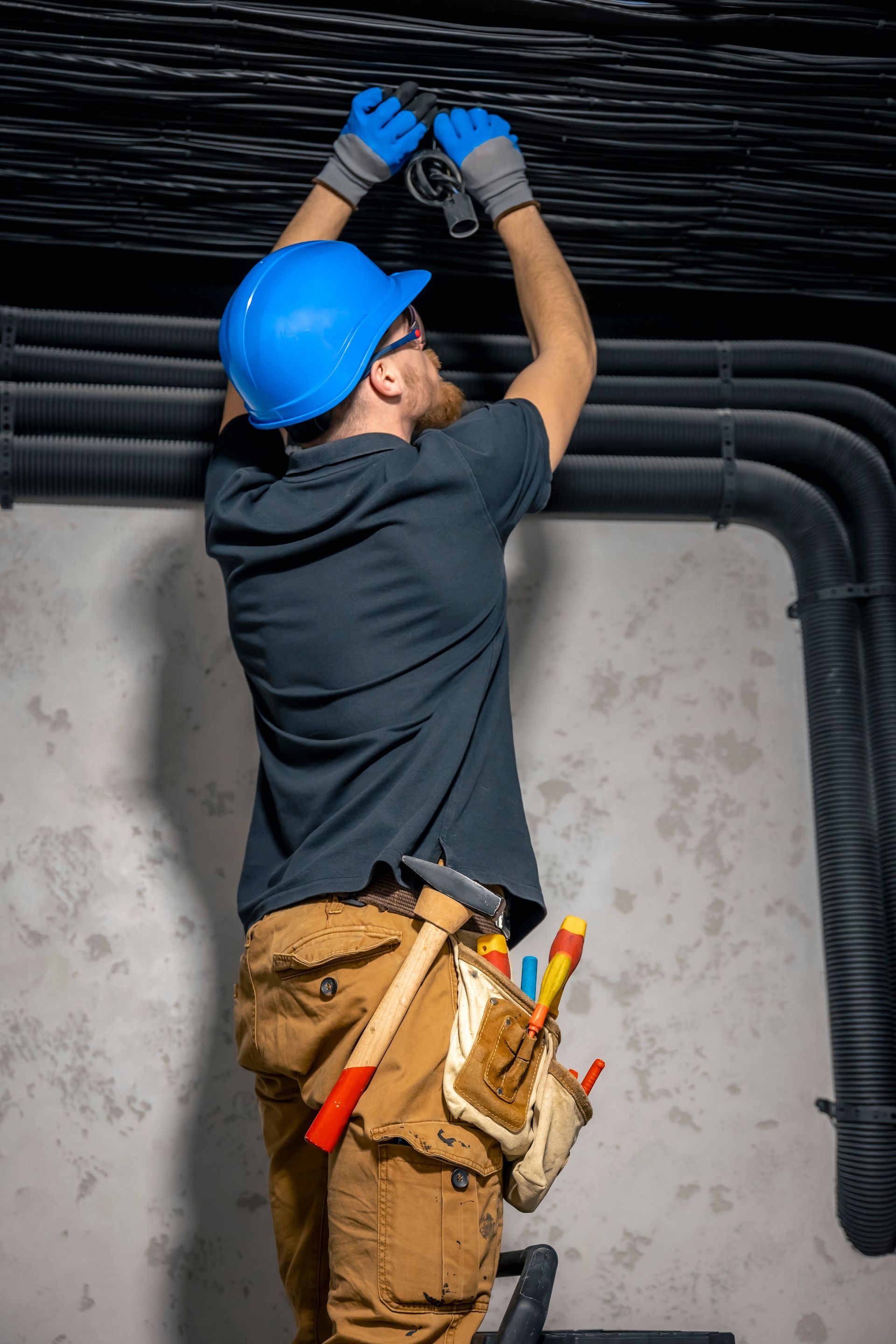 A man in a hard hat is working on a ceiling.