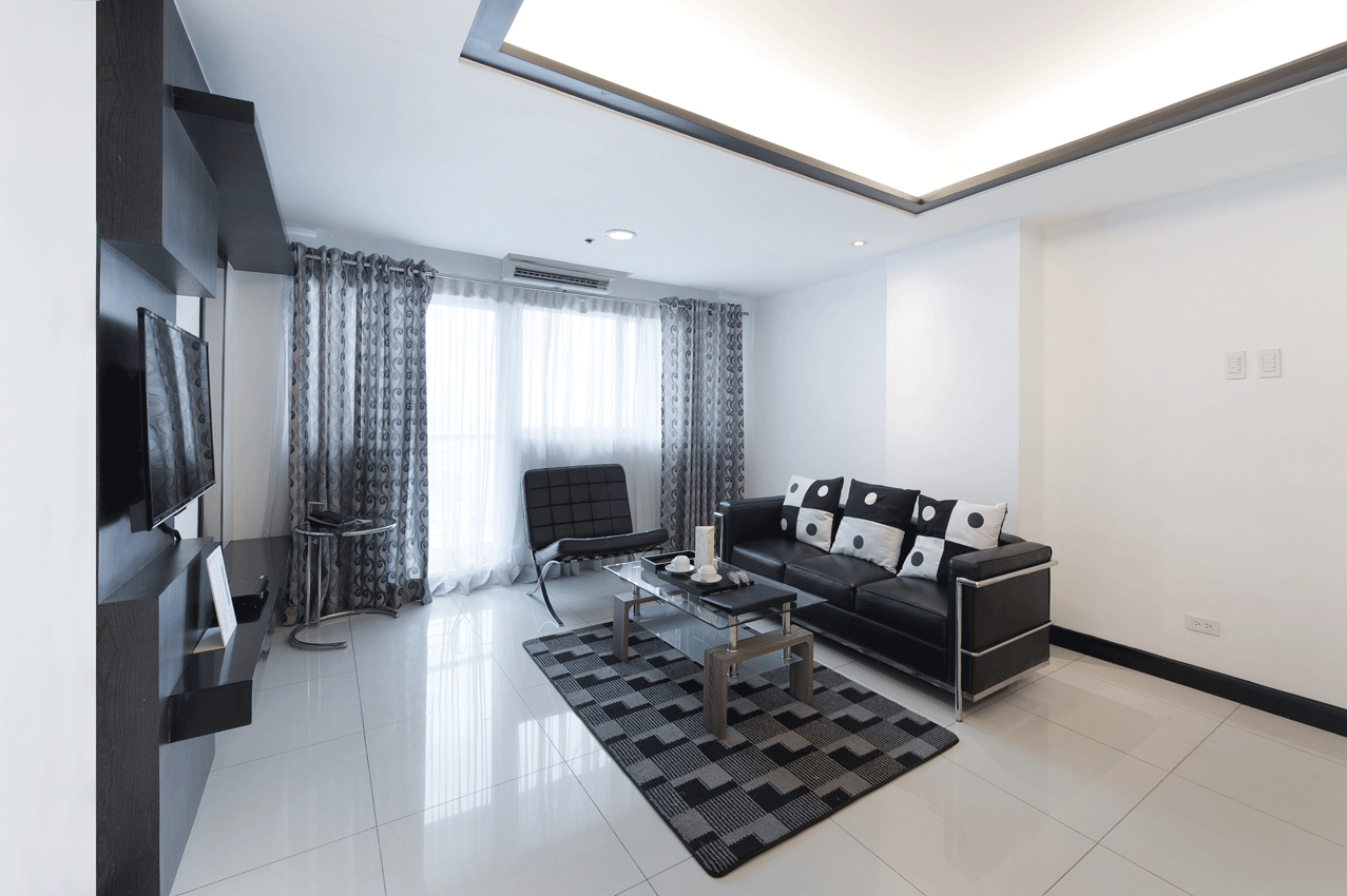 A living room with a couch , chair , coffee table and television.