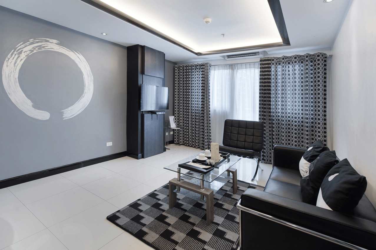 A living room with a couch and chairs  for your staycation in Makati