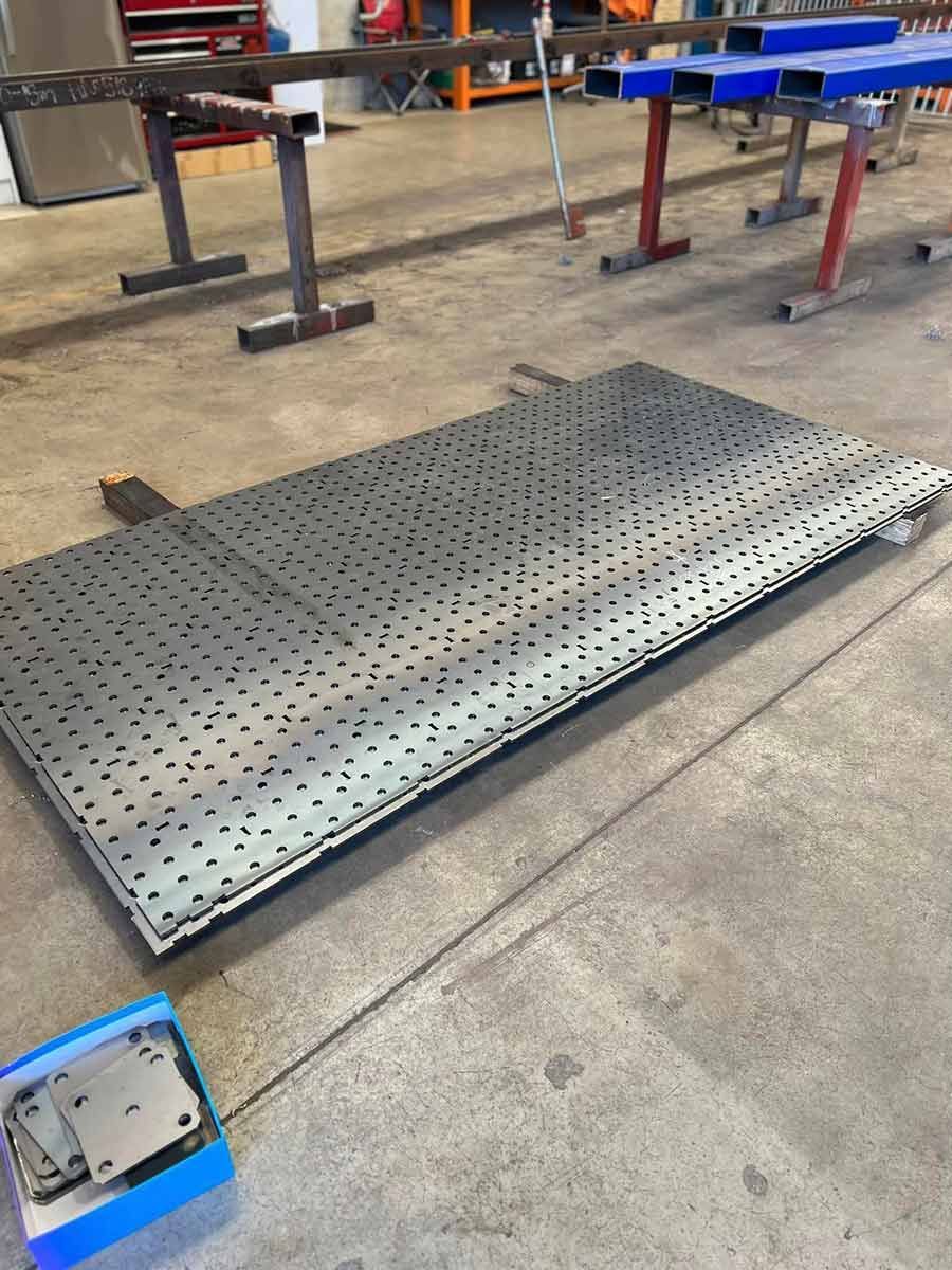A Large Metal Plate With Holes in It is Sitting on a Concrete Floor —  SCF Industries Pty Ltd in Albion Park Rail, NSW