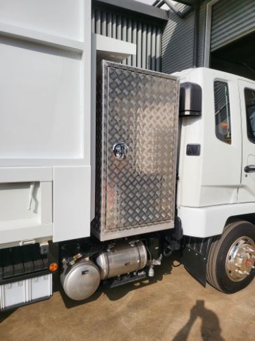 A White Truck With a Stainless Steel Door is Parked in Front of a Building —  SCF Industries Pty Ltd in Albion Park Rail, NSW