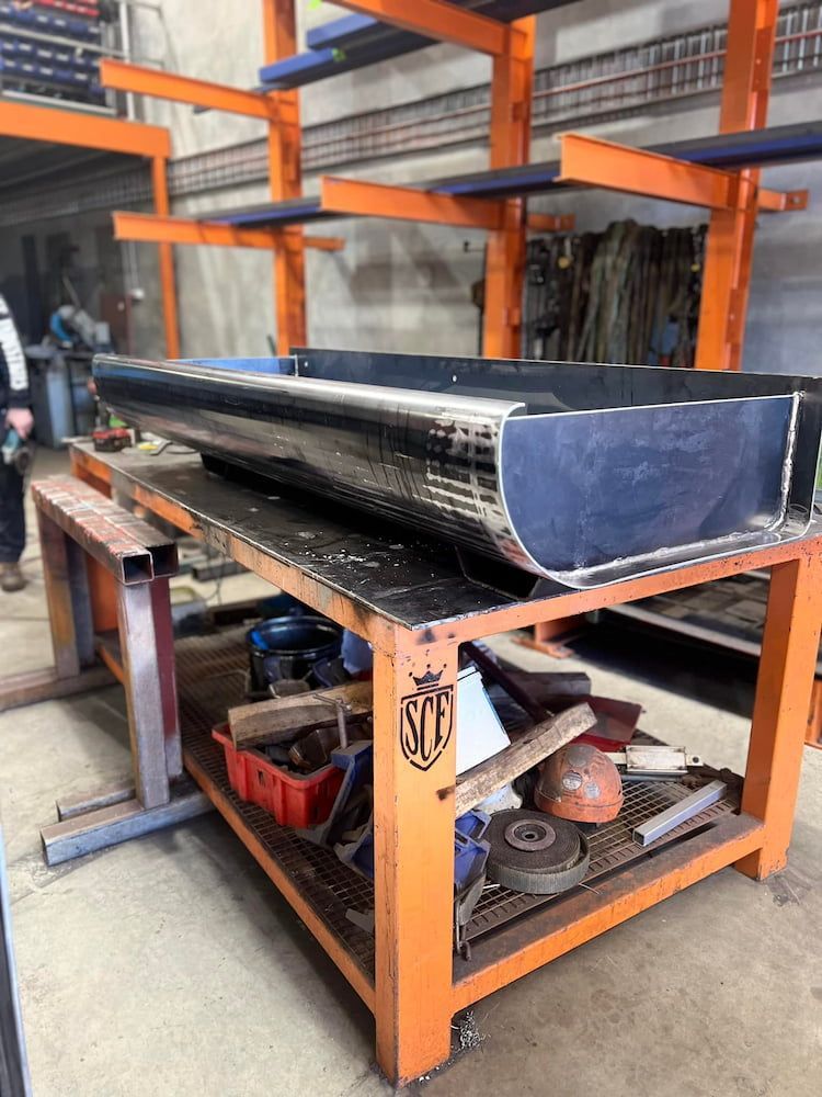 A Large Piece of Metal is Sitting on Top of an Orange Table —  SCF Industries Pty Ltd in Shellharbour, NSW