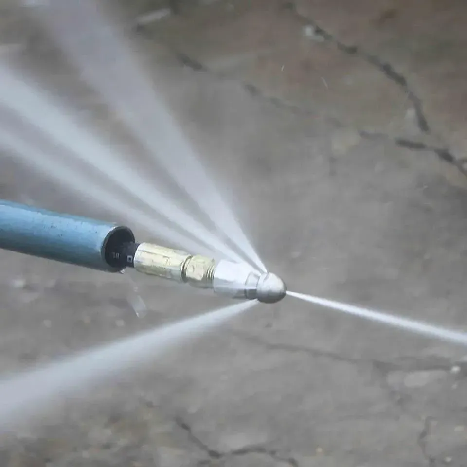 A close up of a high pressure hose spraying water.