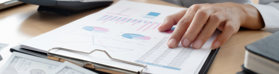 A person is holding a clipboard with a graph on it.