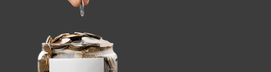 A person is putting a coin into a jar.