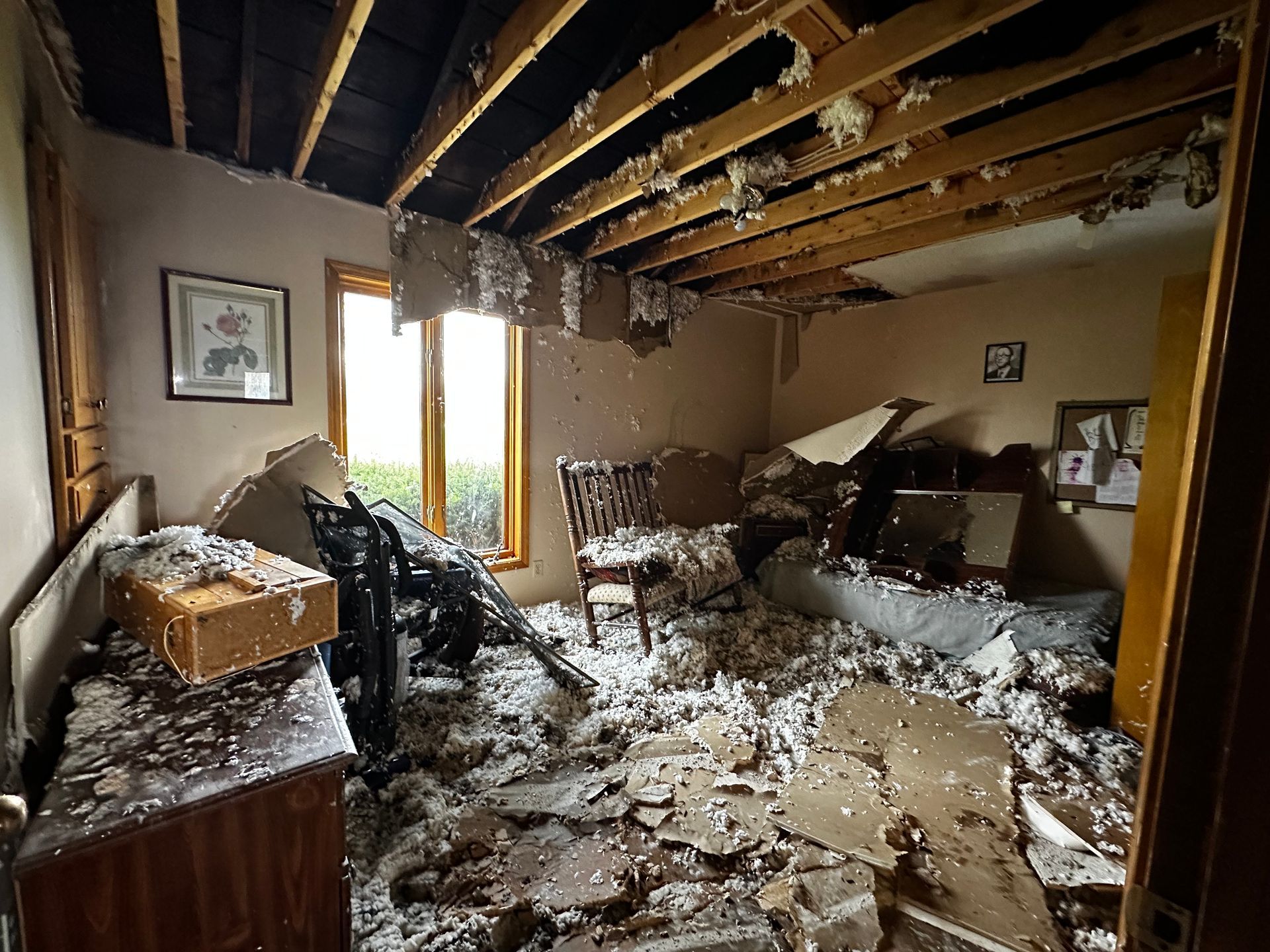 Room interior severely damaged by fire; debris and charred ceiling visible.