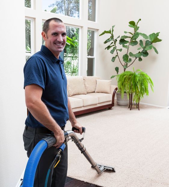 A man is using a vacuum cleaner to clean a carpet in a living room