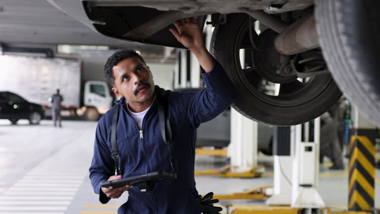 Mechanic inspecting underside of car