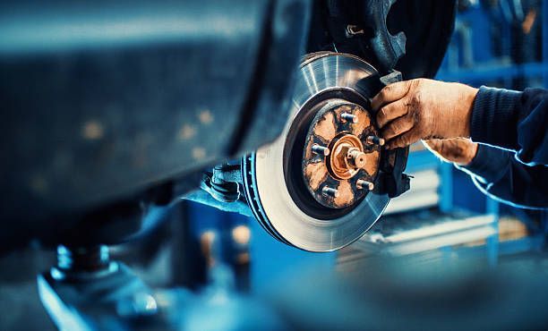 Mechanic fixing car disc brakes close up