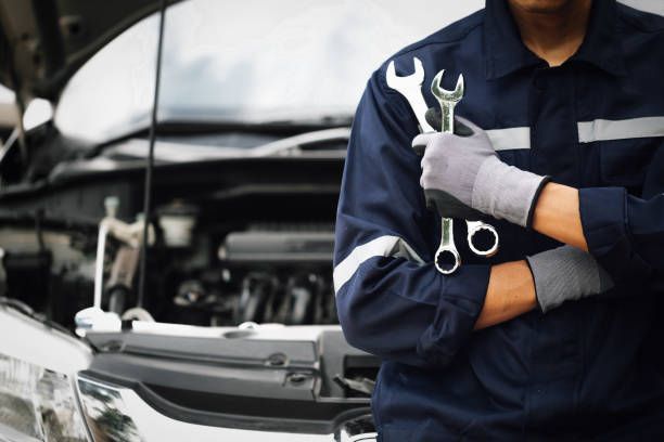 Auto mechanic holding repair wrenches