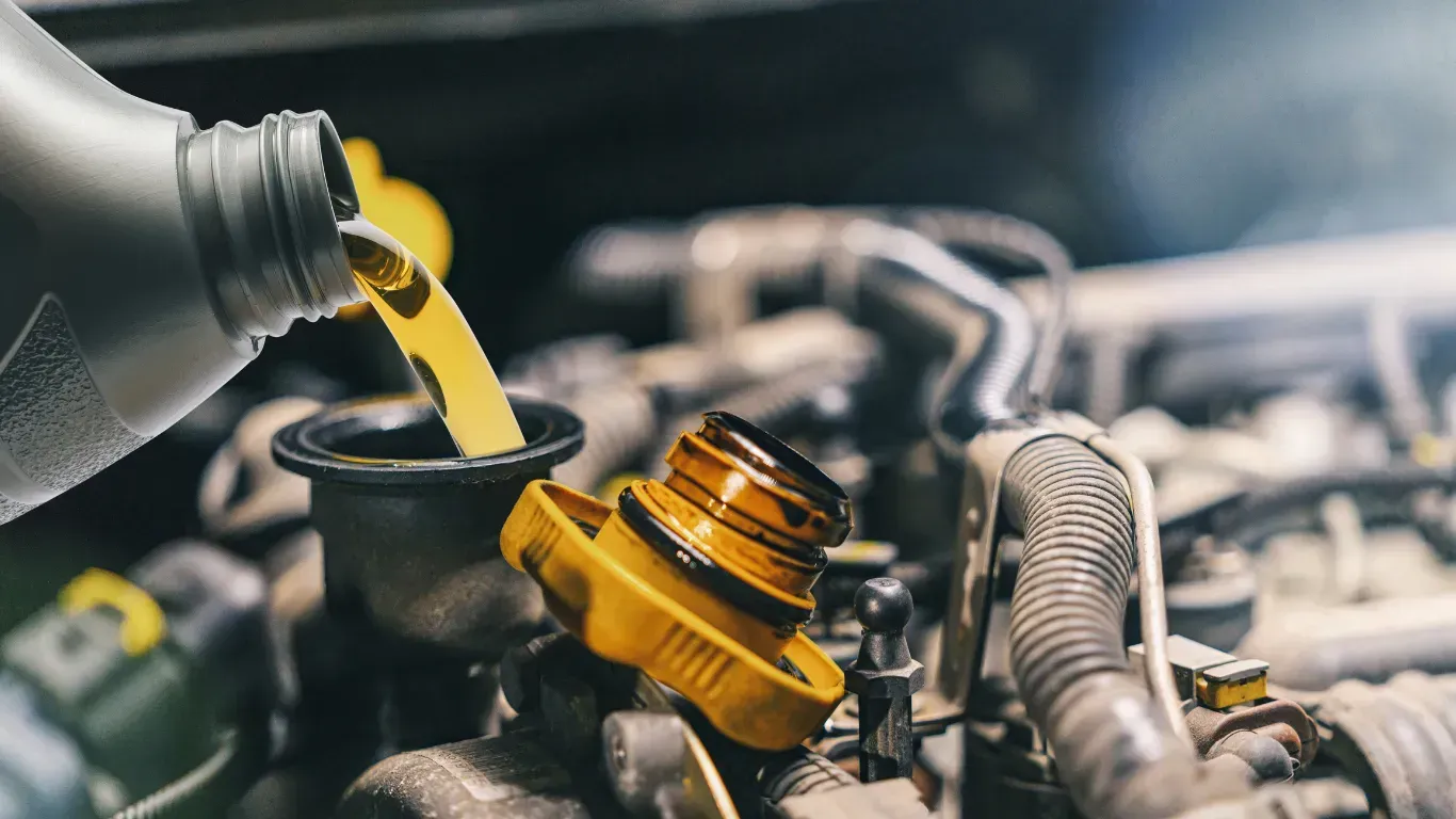 Pouring fresh motor oil into car engine