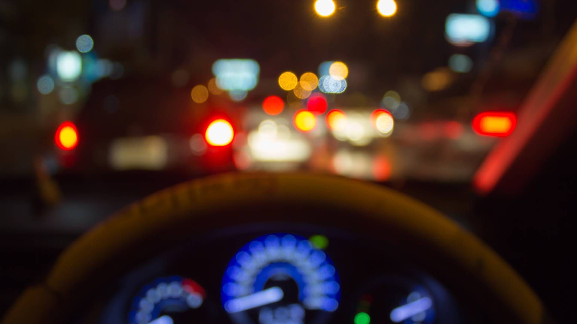 A blurry picture of a person driving a car at night.