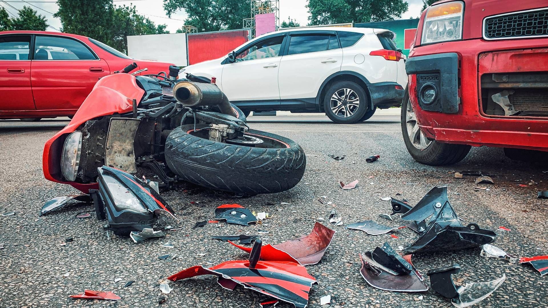 A motorcycle and a car are damaged in a traffic accident.