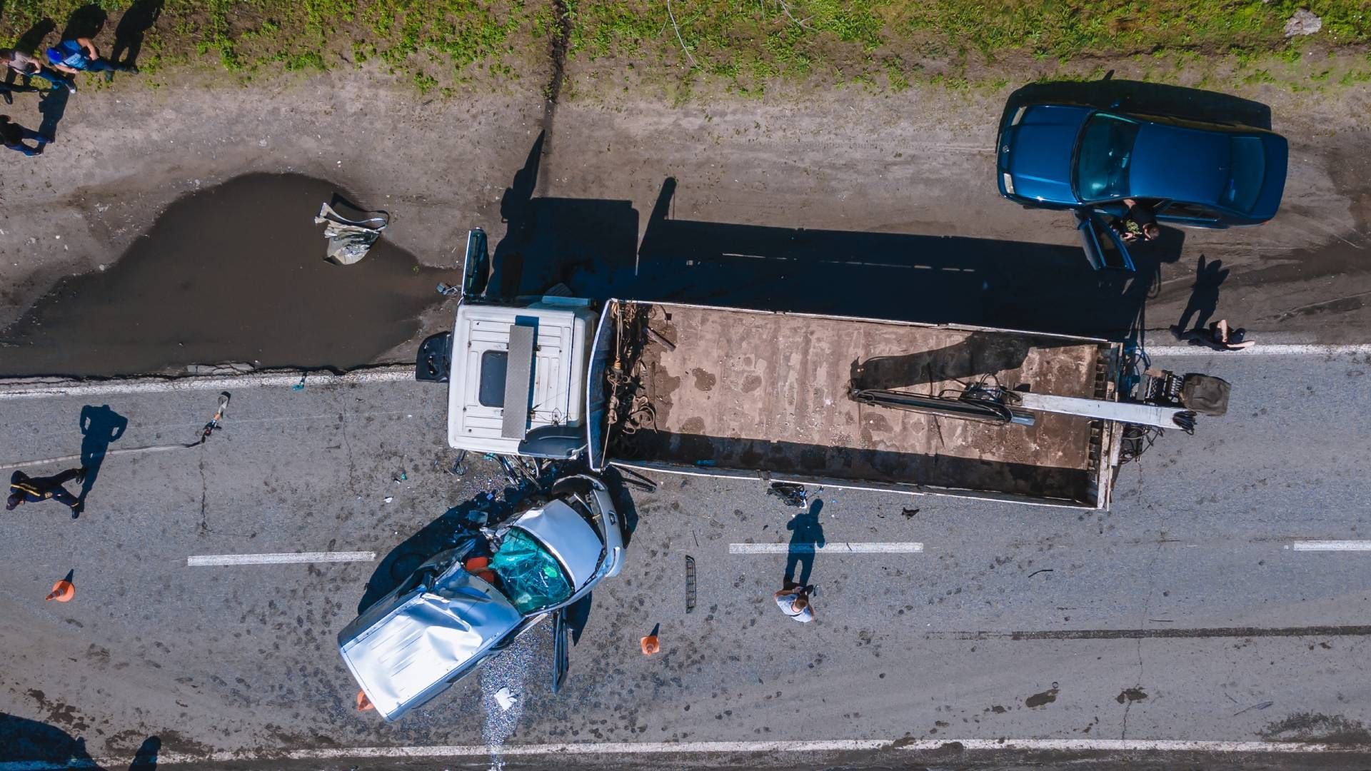 An aerial view of a car that has crashed into a truck.