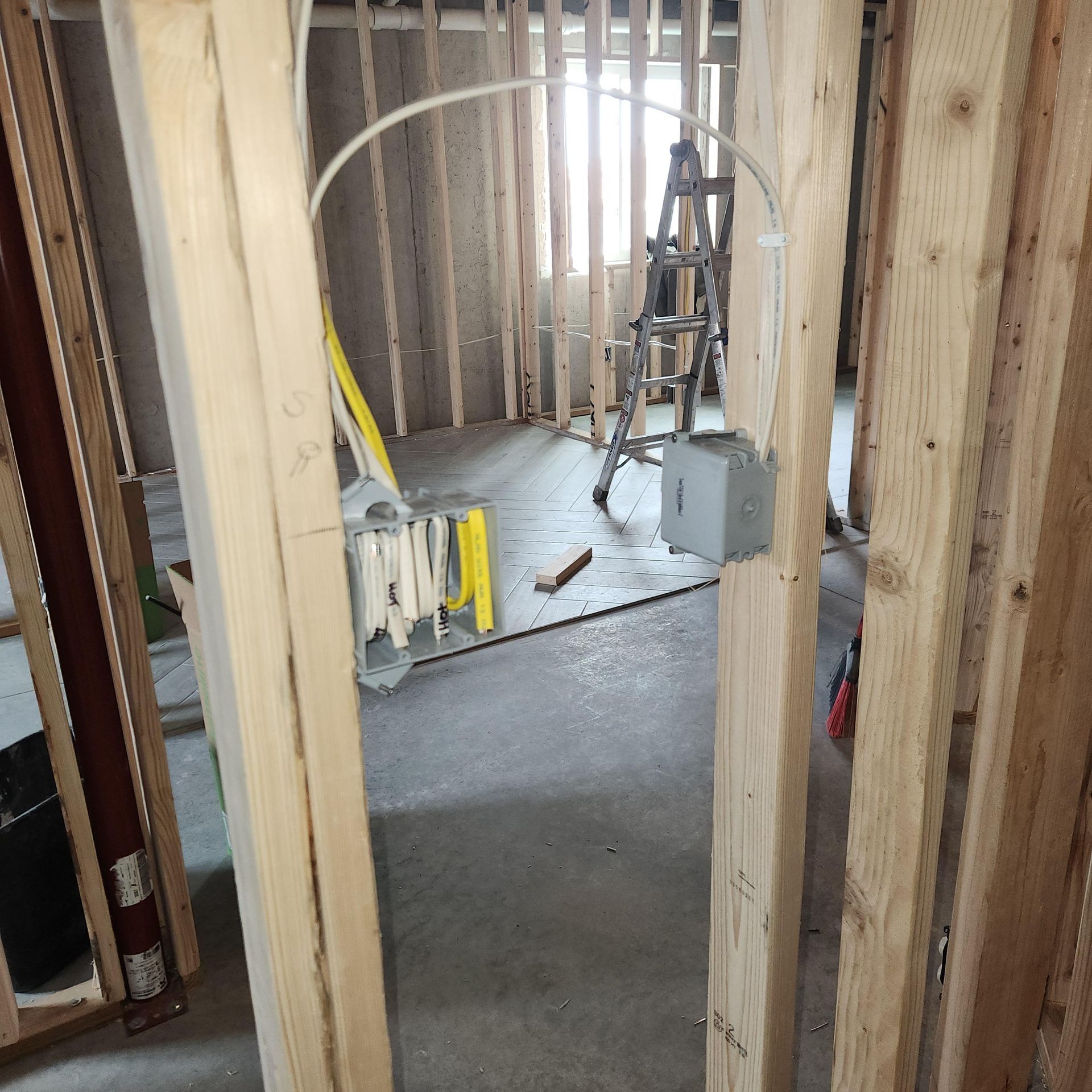 A ladder is sitting on the floor in a room under construction