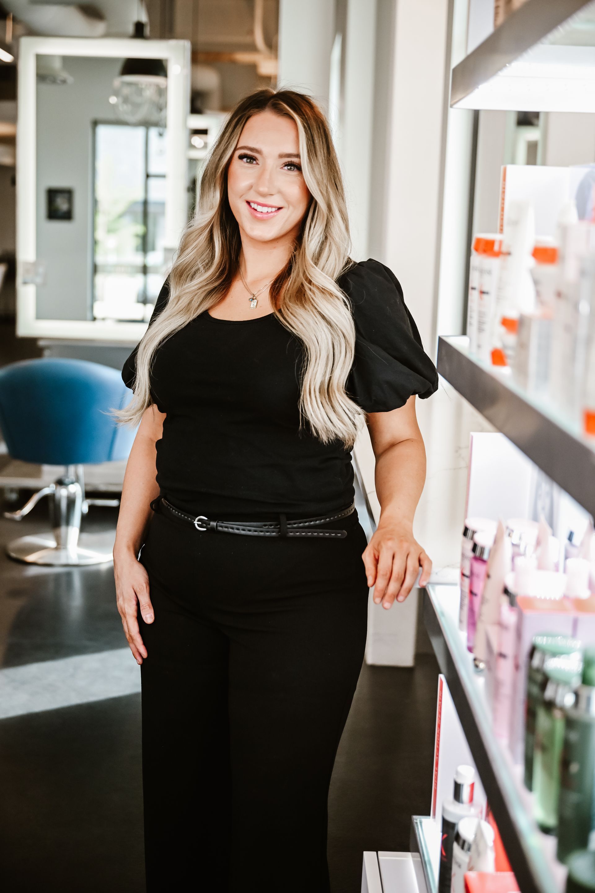 a silhouette of a woman in a dress standing with her hands in her pockets .