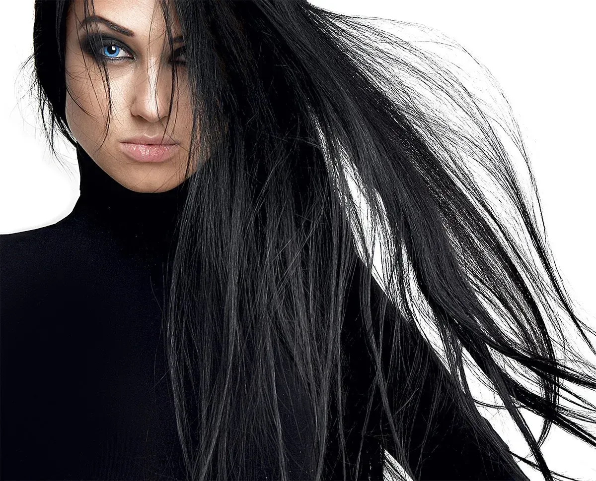 A woman with long black hair is wearing a black turtleneck