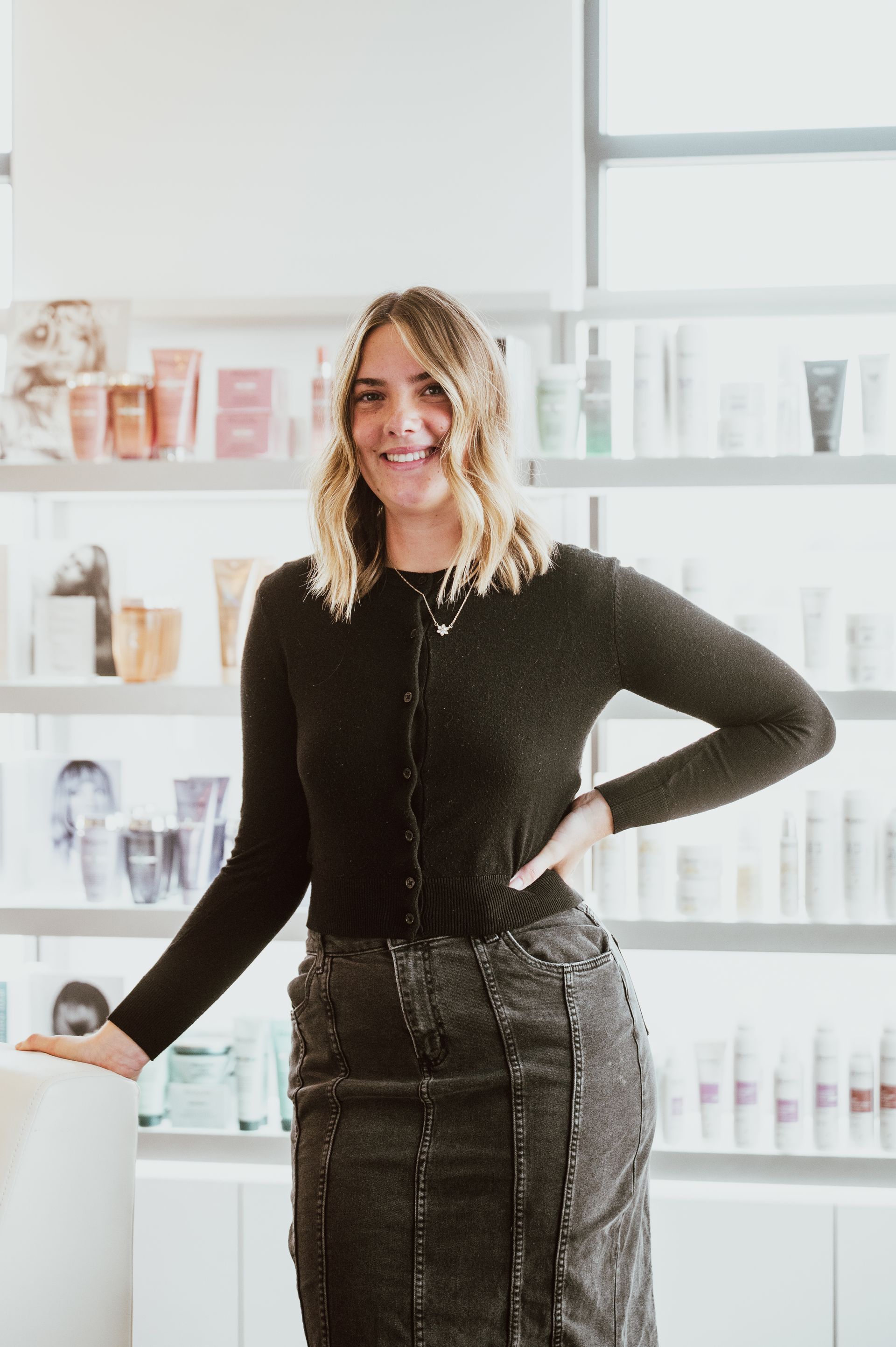 A woman in a black shirt is sitting in a black chair.