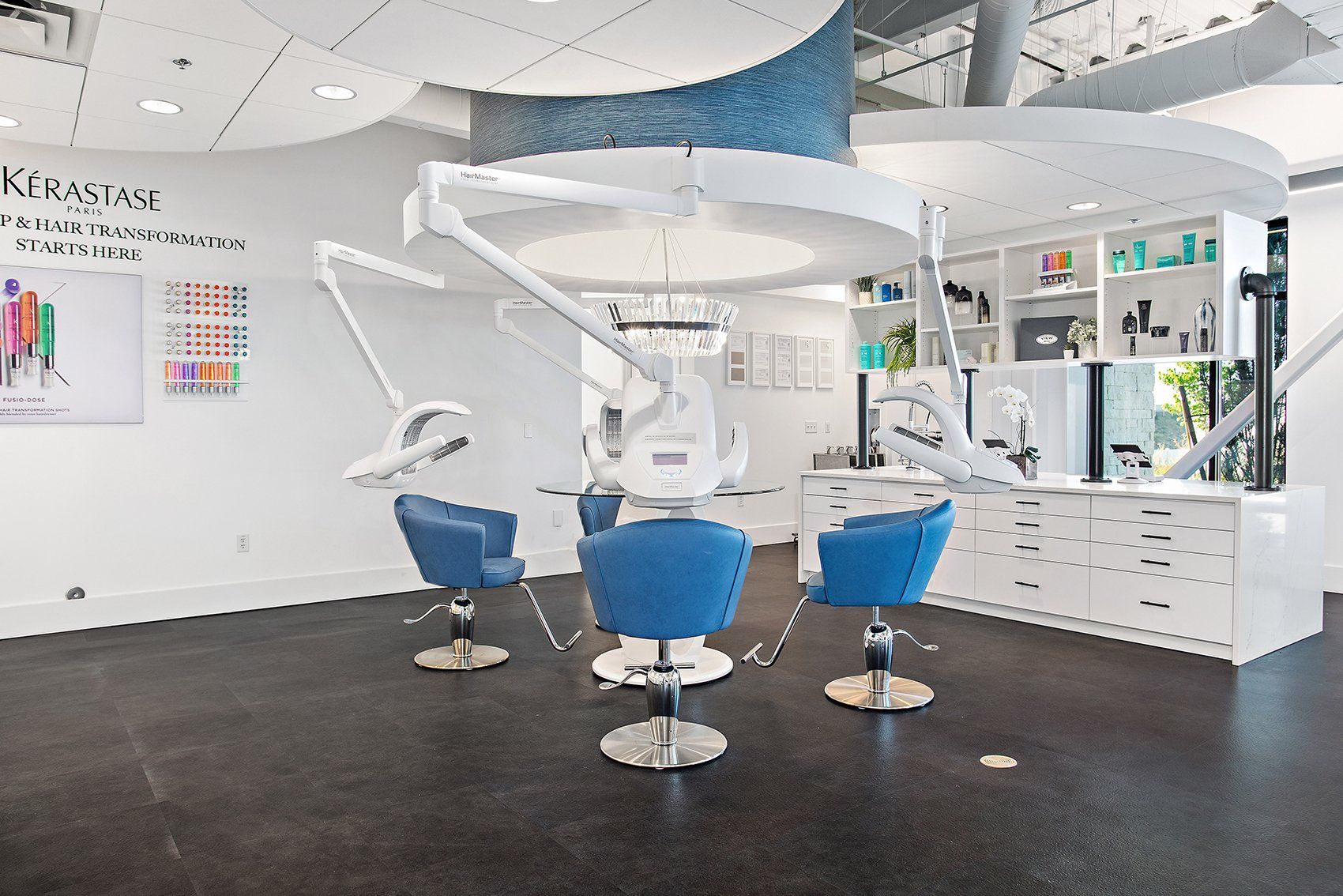 A salon with blue chairs and a ceiling fan.