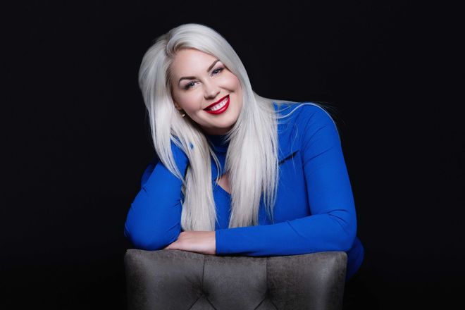 AnneMarie Krainich, owner Ottalaus Salon, in a blue shirt behind a chair