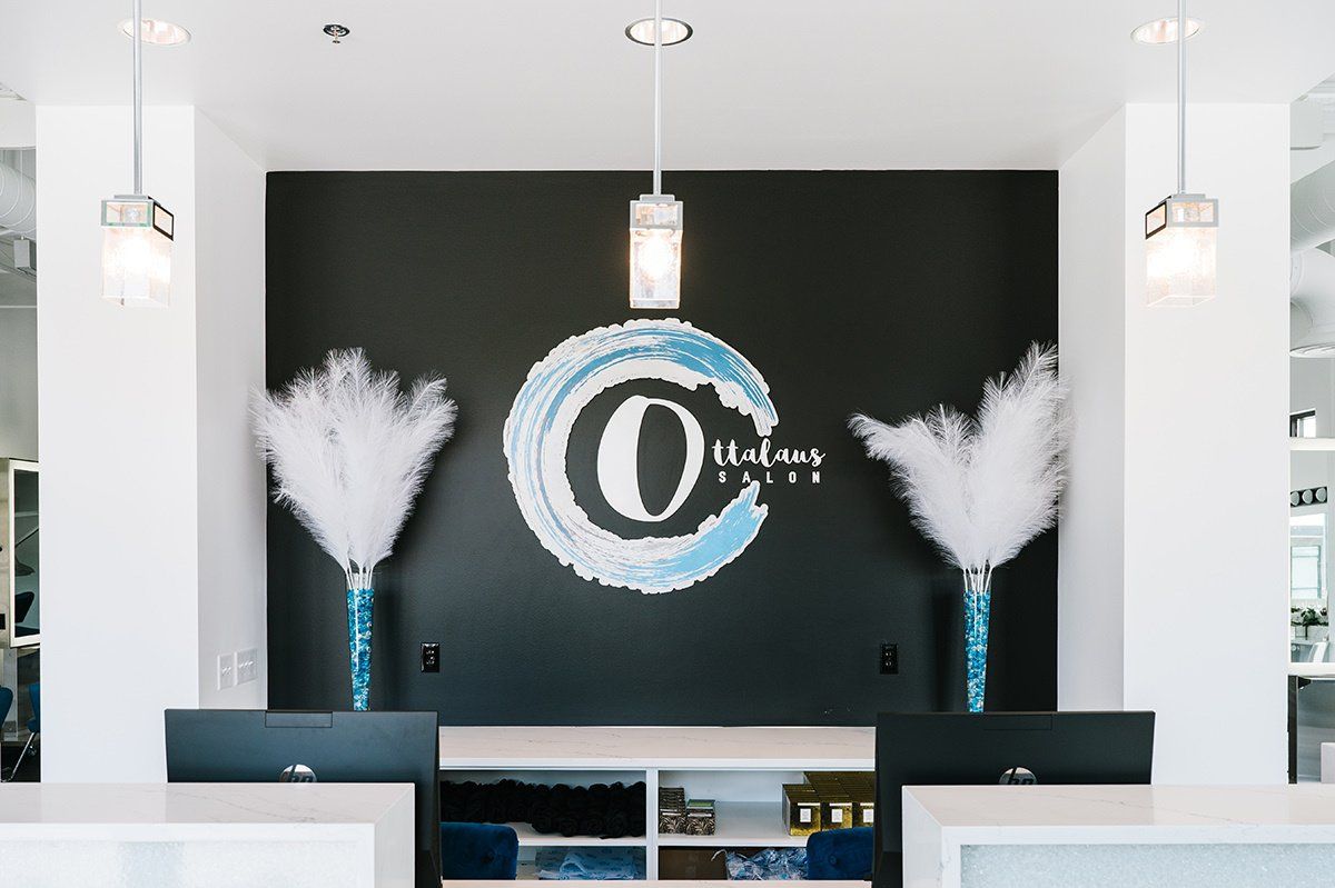 A reception area with a black wall and a logo on it.