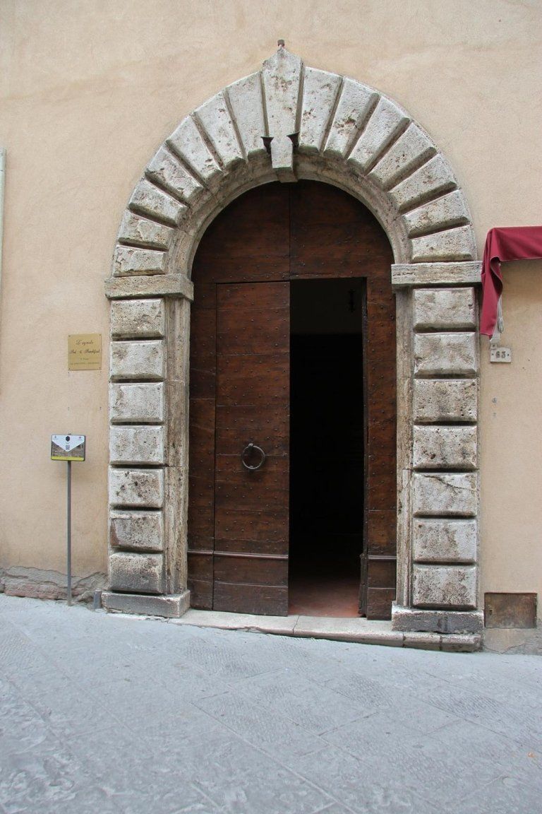 Antico arco di pietra dove si apre la vechia porte in legno massiccio della casa