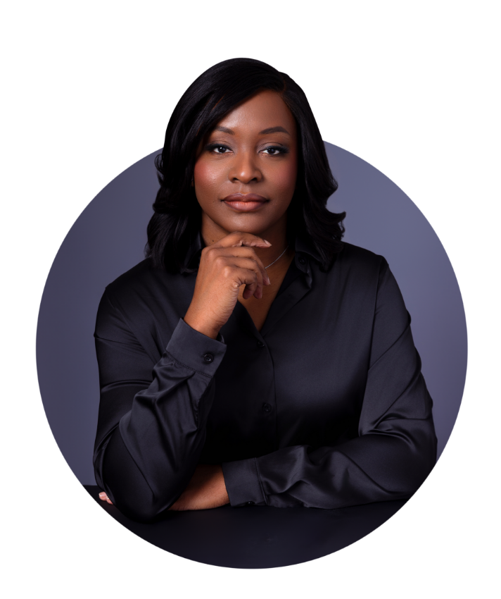 Woman in black shirt, hand on chin, looking at the viewer. In a dark setting.