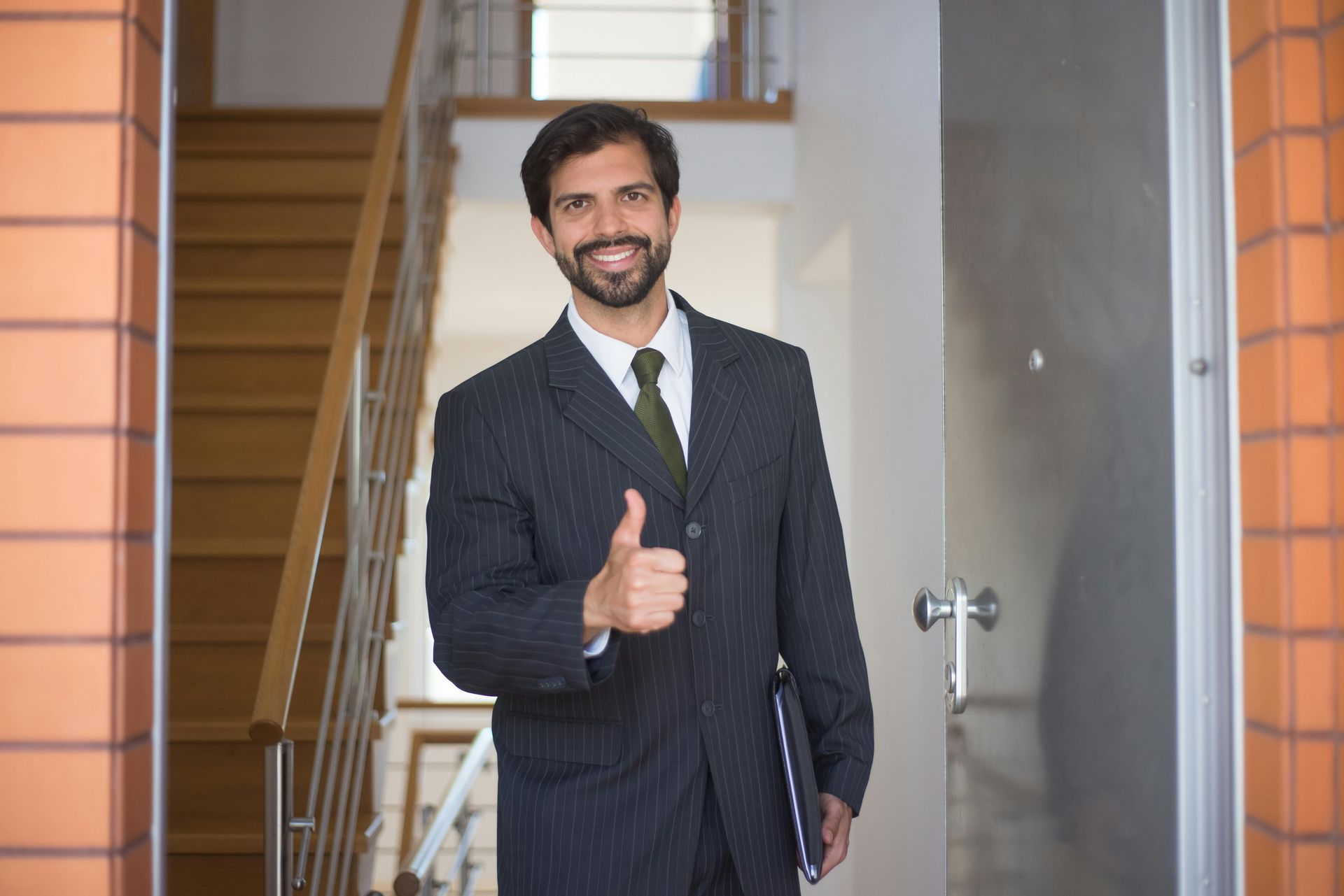 A man in a suit and tie is giving a thumbs up.