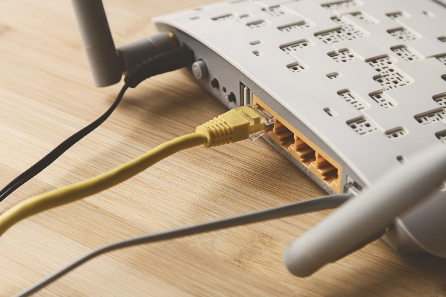 Close-Up of A White Wi-Fi Router with A Yellow Ethernet Cable Plugged In — Ryphen Electrical in Highton, VIC
