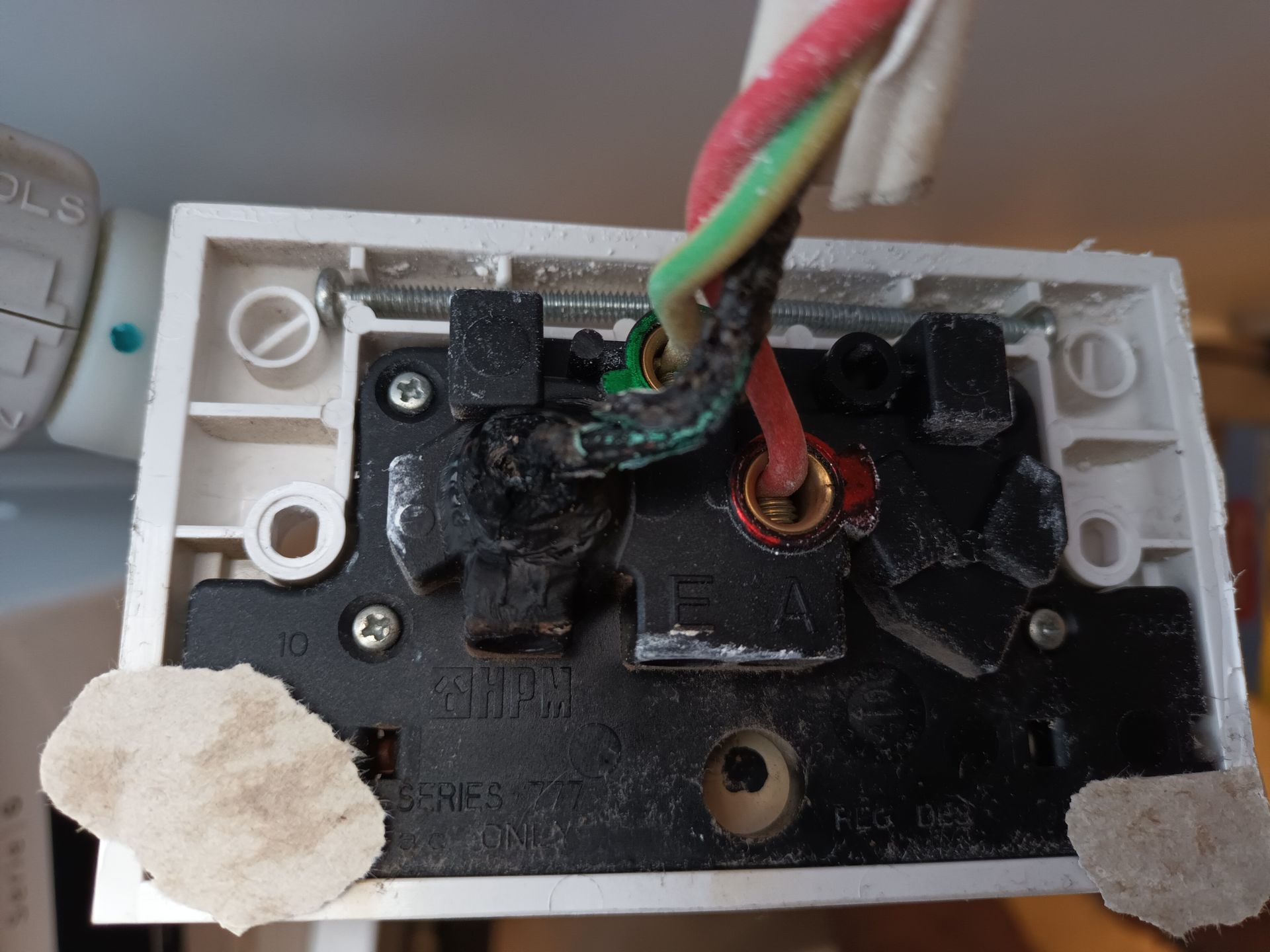 Damaged electrical outlet with charred wires; black plastic, red and green wires, white frame. — Ryphen Electrical in Highton, VIC