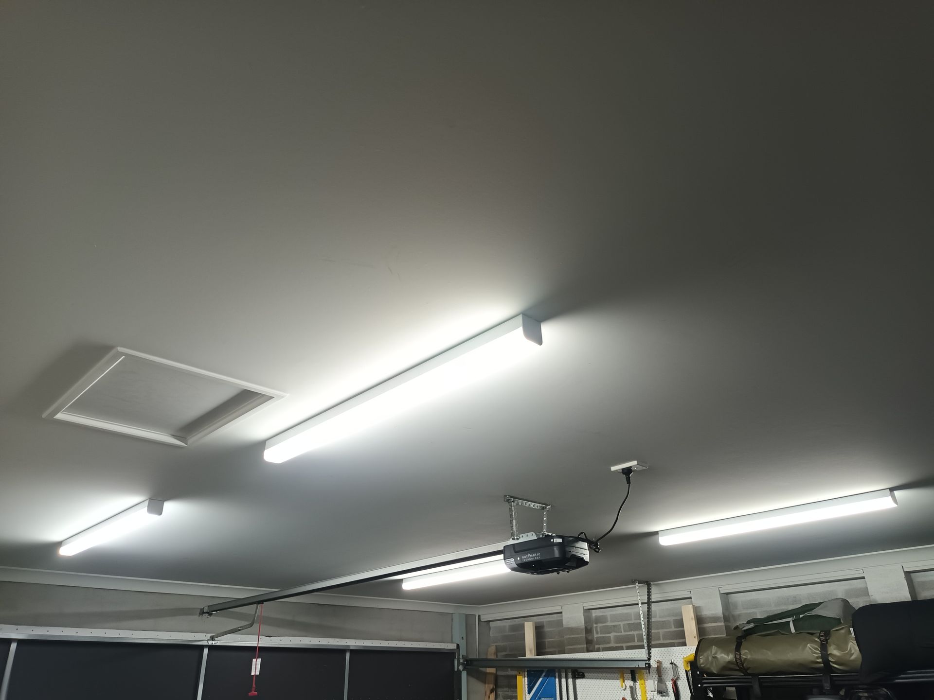 Garage ceiling with bright fluorescent lights, a ceiling fan, and access panel. — Ryphen Electrical in Highton, VIC