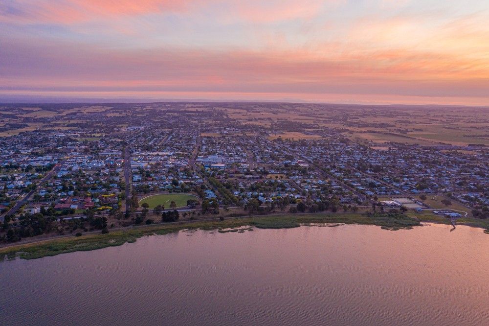 Aerial View of A Town Beside a Lake at Sunset; Pink and Orange Sky — Ryphen Electrical in Colac, VIC