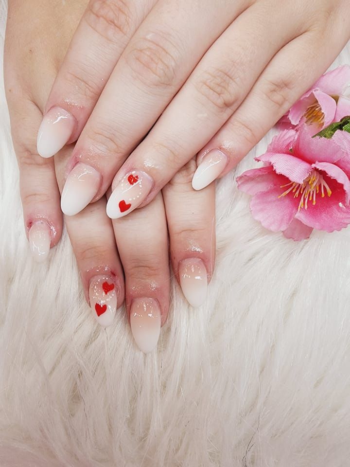 A close-up of a person's nails with hearts on them.