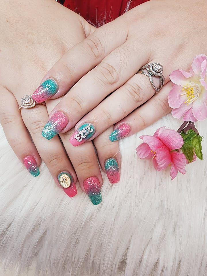 A close-up of a woman's nails with a ring on her finger.