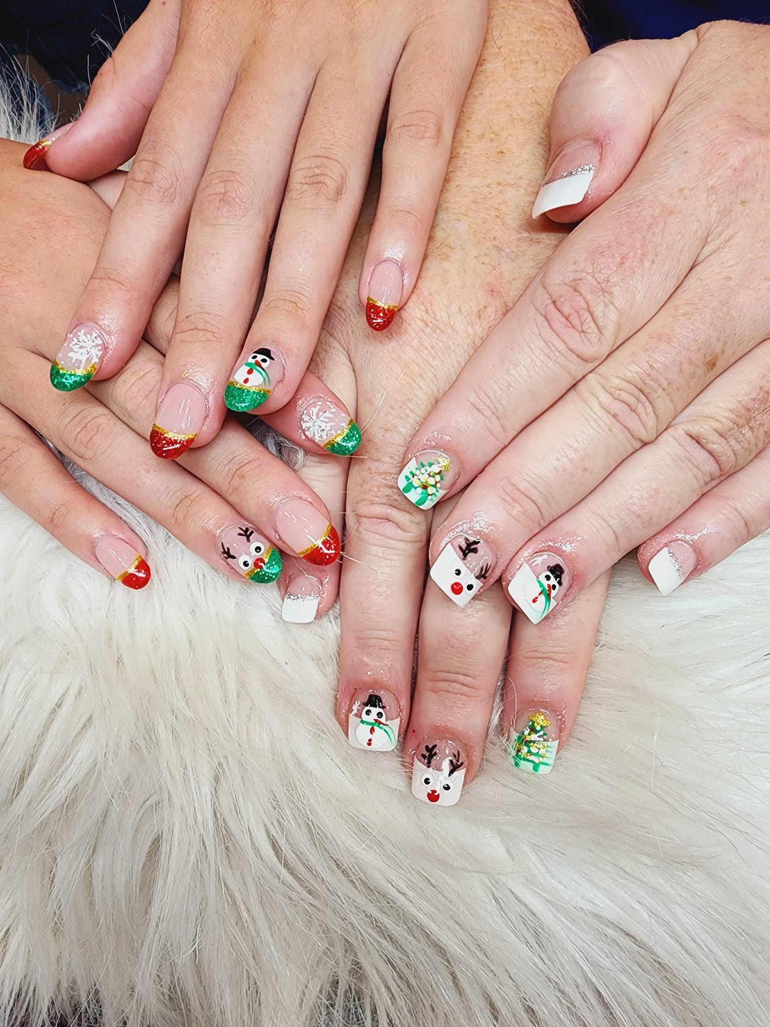 A close up of a person 's nails with christmas designs on them.