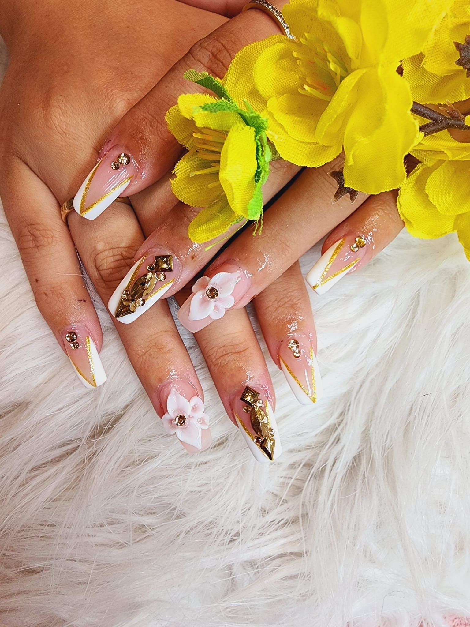 A close up of a woman's nails with yellow flowers on them.