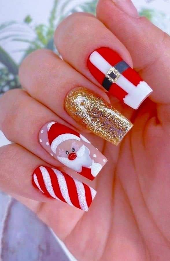 A woman's nails are decorated with Santa Claus and candy canes.