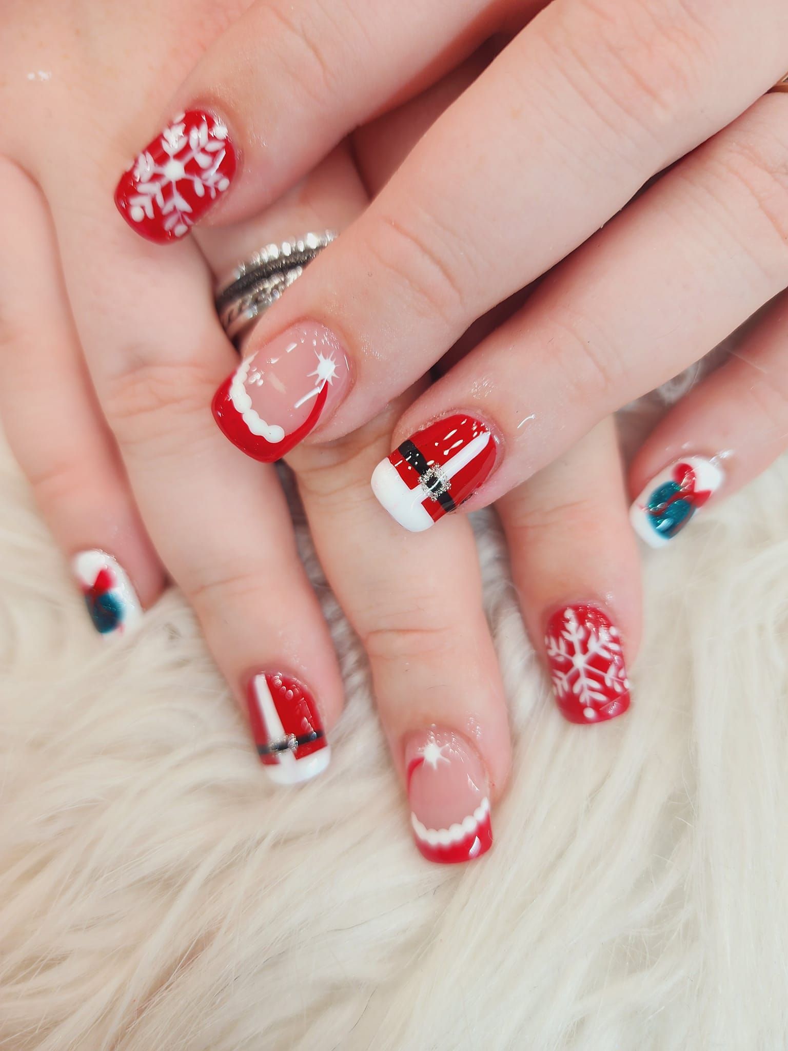 A close-up of a person's nails with Christmas designs on them