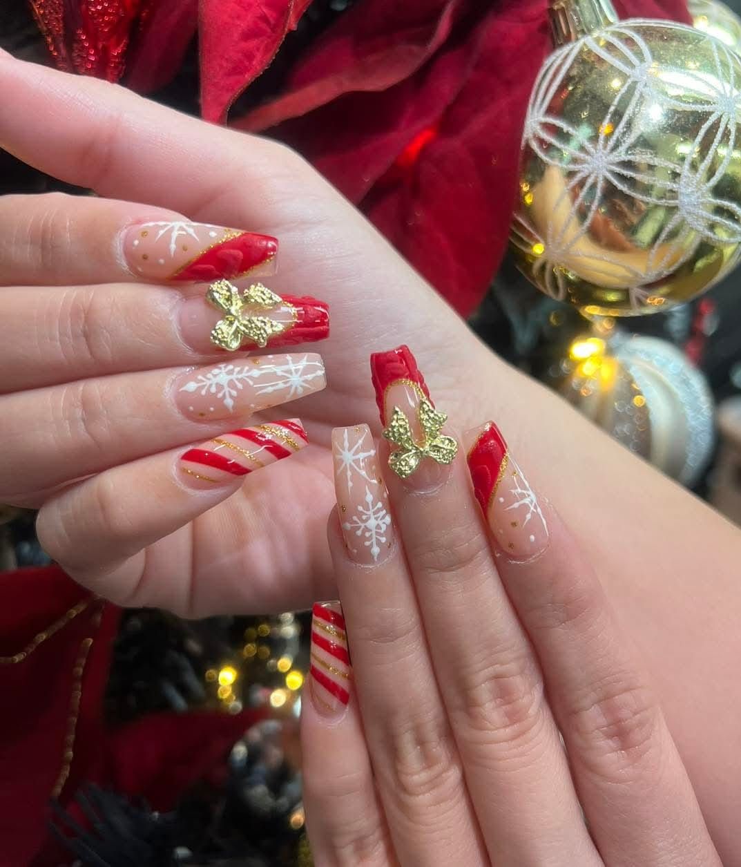 A close up of a woman 's hand with christmas nails.