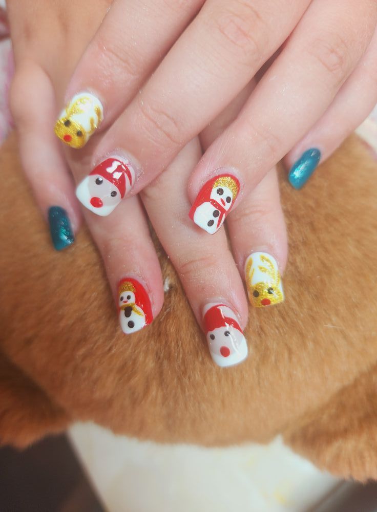 A close up of a person 's nails with christmas designs on them.