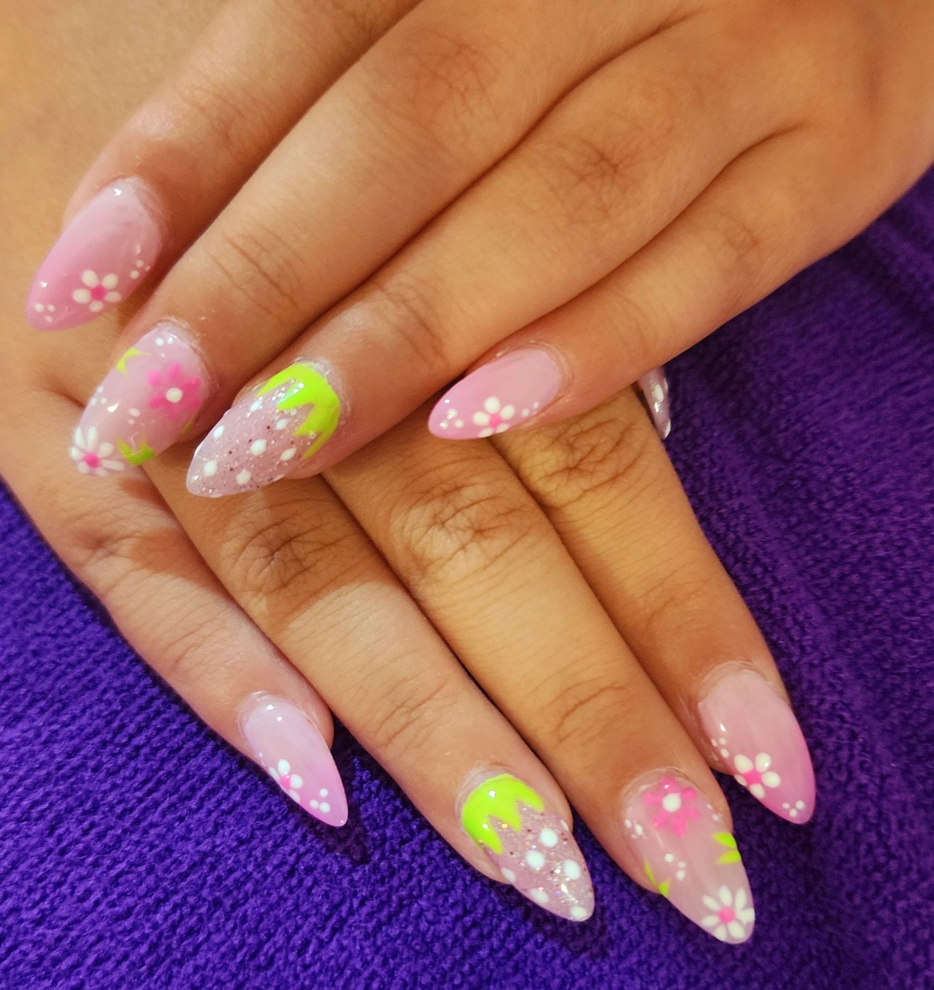 A close-up of a woman's nails on a purple towel.