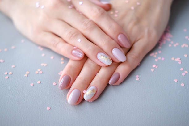 A close-up of a woman's hands with a manicure on a table.