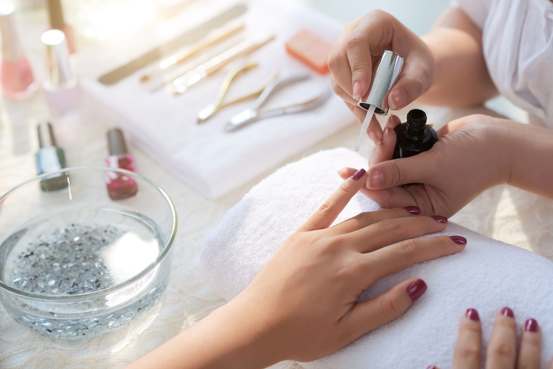A woman is getting her nails painted at a nail salon.