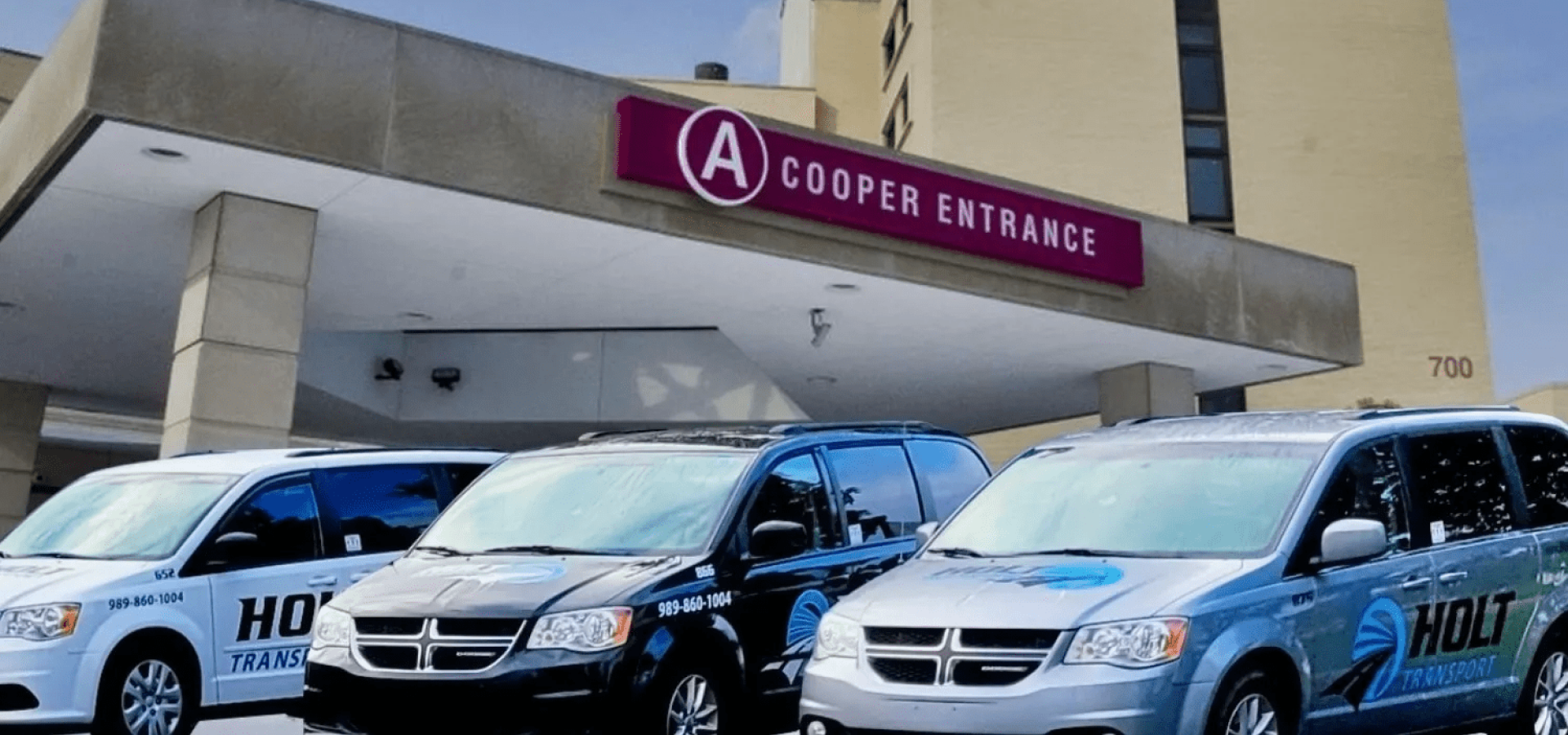 Several vans are parked in front of a cooper entrance