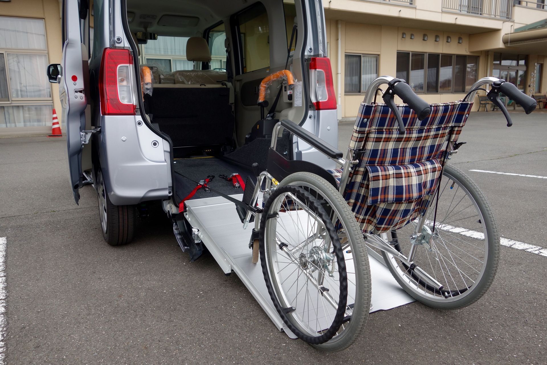 A wheelchair is being lifted into the back of a van.