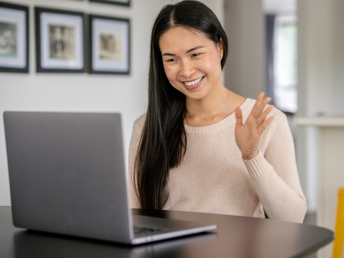 Caregiver's hands holding the hands of an elderly person, possibly in a wheelchair, outdoors.