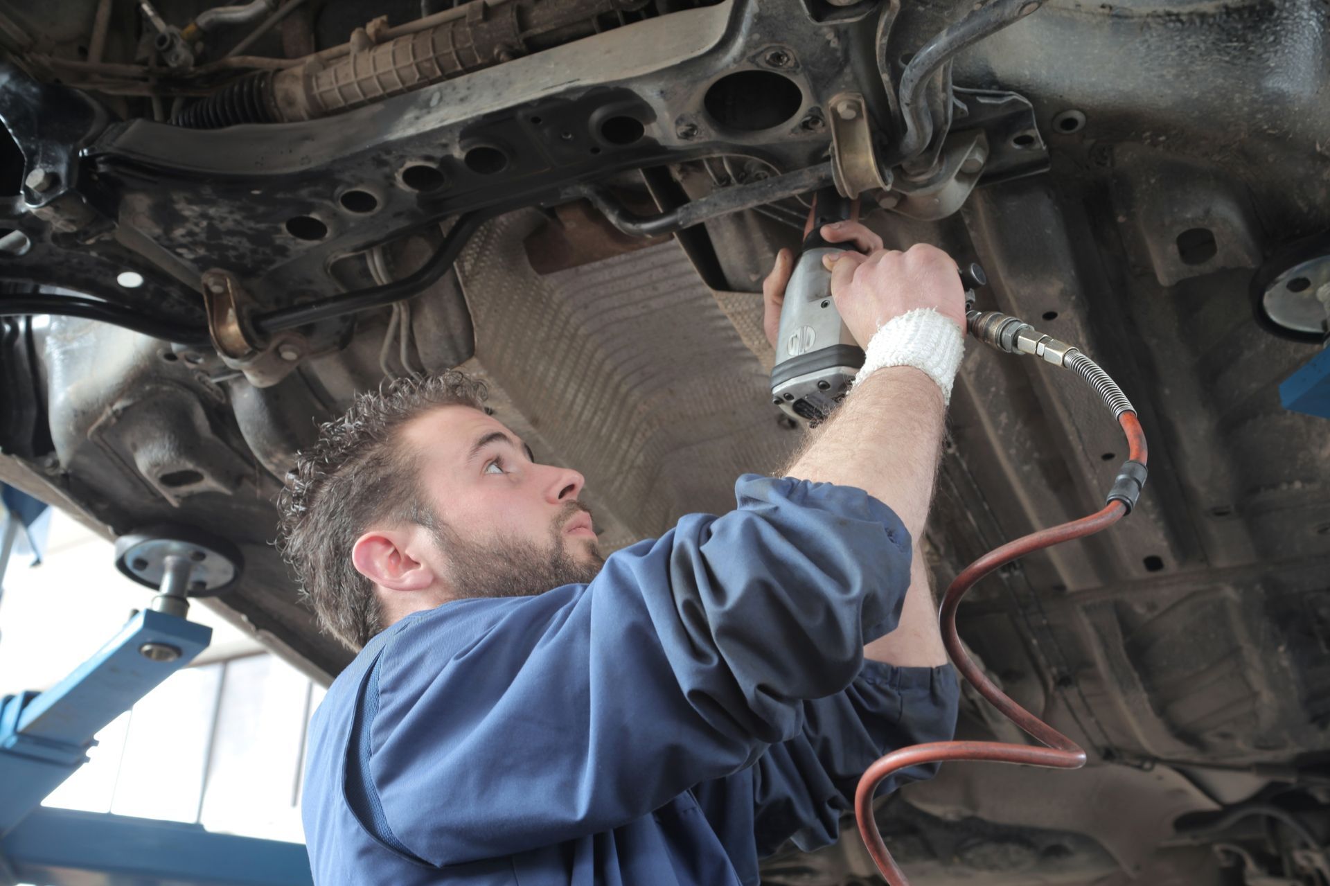 Un hombre está trabajando en la parte inferior de un coche.